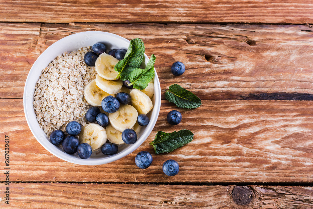 Nice breakfast table. Bowl of blueberries and fruits on a wooden table Nice breakfast table. Bowl of blueberries and fruits on a wooden table