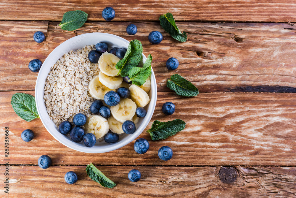 Nice breakfast table. Bowl of blueberries and fruits on a wooden table Nice breakfast table. Bowl of blueberries and fruits on a wooden table