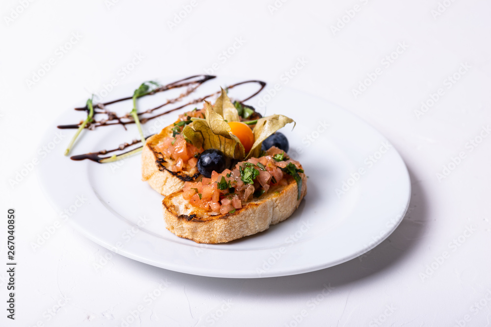 Delicious Italian antipasti bruschetta on white background. Close-up. Delicious Italian antipasti bruschetta on white background. Close-up.