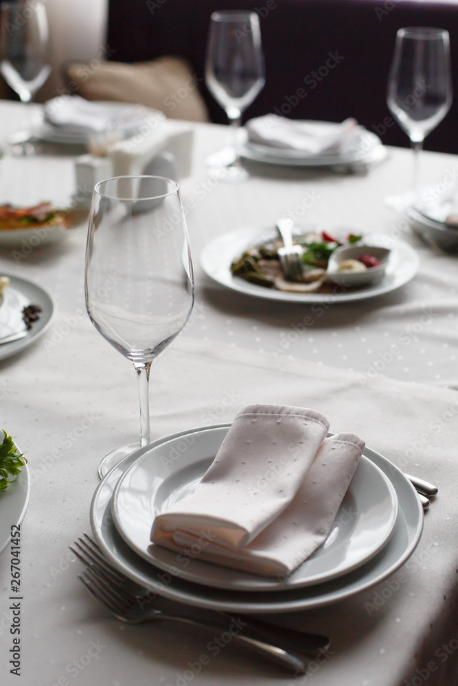 Served for banquet restaurant table with dishes, snack, cutlery, wine and water glasses, european food, selective focus Served for banquet restaurant table with dishes, snack, cutlery, wine and water glasses, european food, selective focus