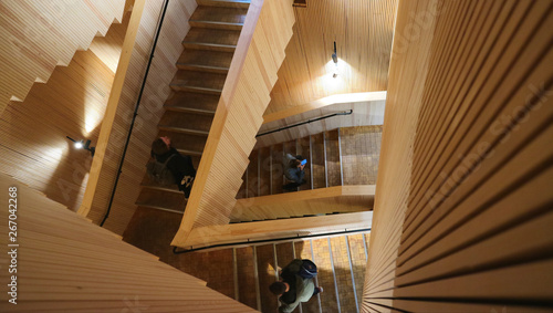 People walking on a timber staircase and forming an interesting pattern