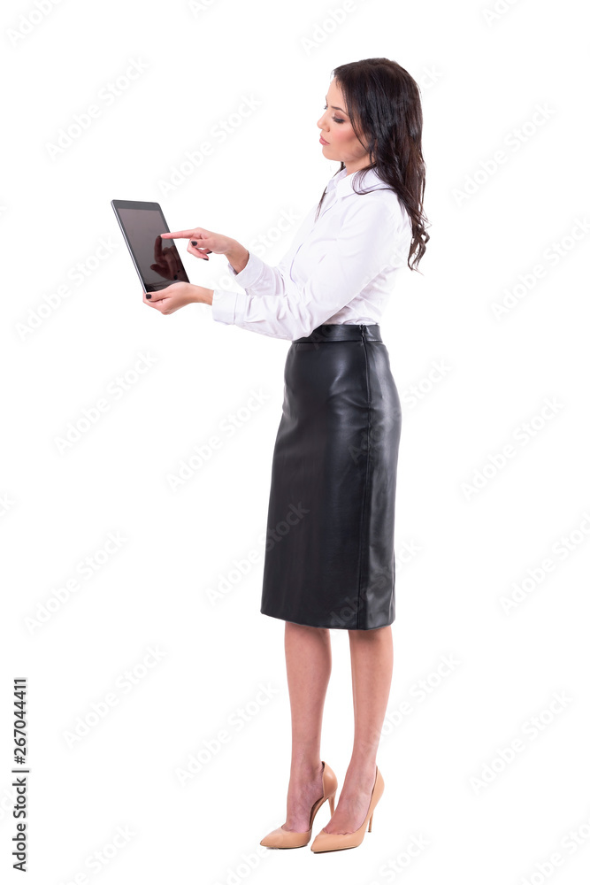 Side view of elegant young business woman using interactive tablet touch screen. Full body isolated on white background. Side view of elegant young business woman using interactive tablet touch screen. Full body isolated on white background.