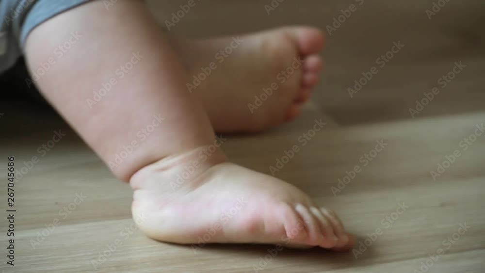 close-up of children's legs taking their first steps and falling down close-up of children's legs taking their first steps and falling down