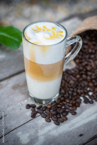 Hot caramel coffee in glass with coffee beans