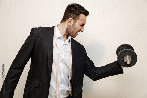 Muscular Office worker  holding a dumbbell in his hand sport and oddice conceptions  photo