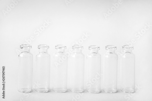 Group Medicine vials with open neck without stopper. Empty glass medical ampoules in a row with black and white colors. Vaccines, Medicine, Immunization concept.