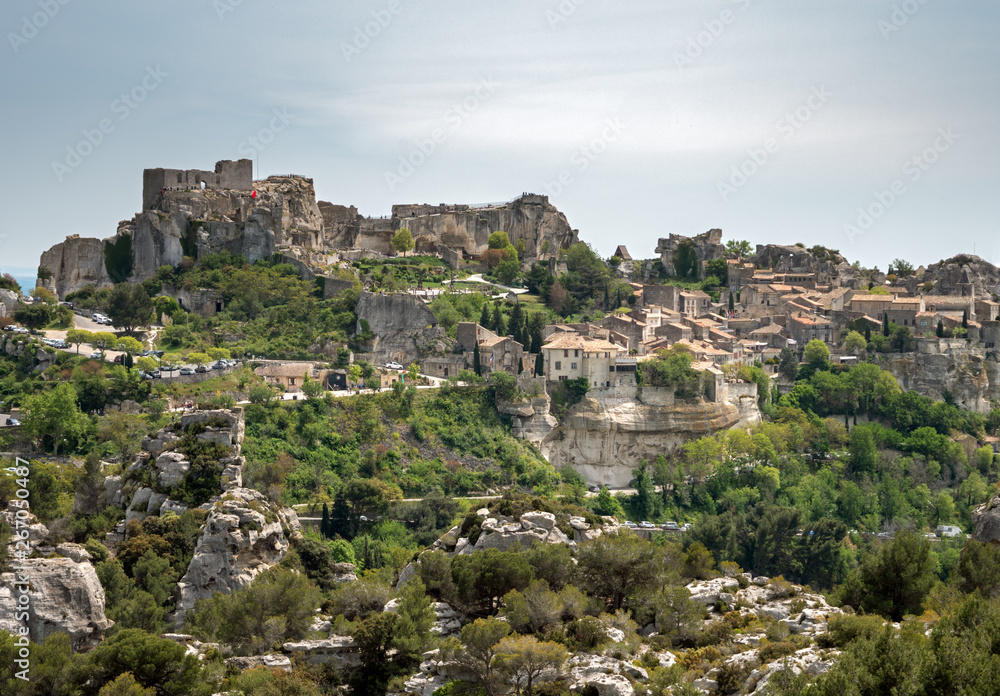 An old french castle town stands at the tops of a Rugged cliff, surrounded by forests and rocks. Located in the south of France.
