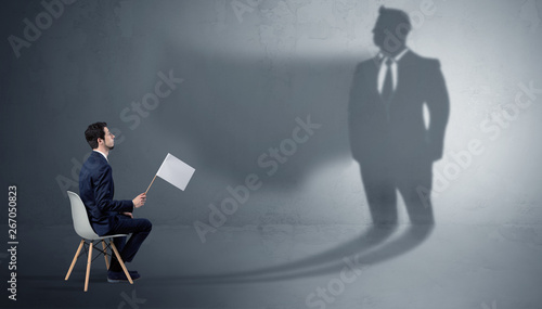 Photos Humble businessman staying and offering stuffs to a huge angry bull shadow