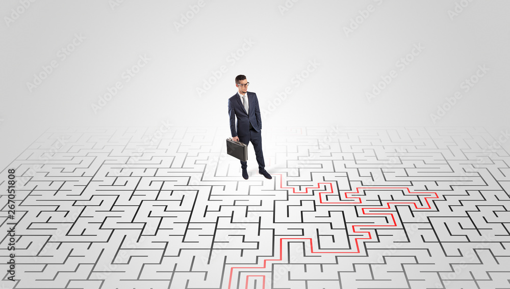 Young entrepreneur standing in a middle of a labyrinth with the solution
Young entrepreneur standing in a middle of a labyrinth with the solution