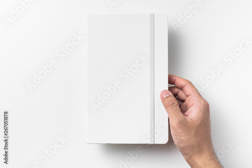 Fototapeta Naklejka Na Ścianę i Meble -  white notebook hold by man hand