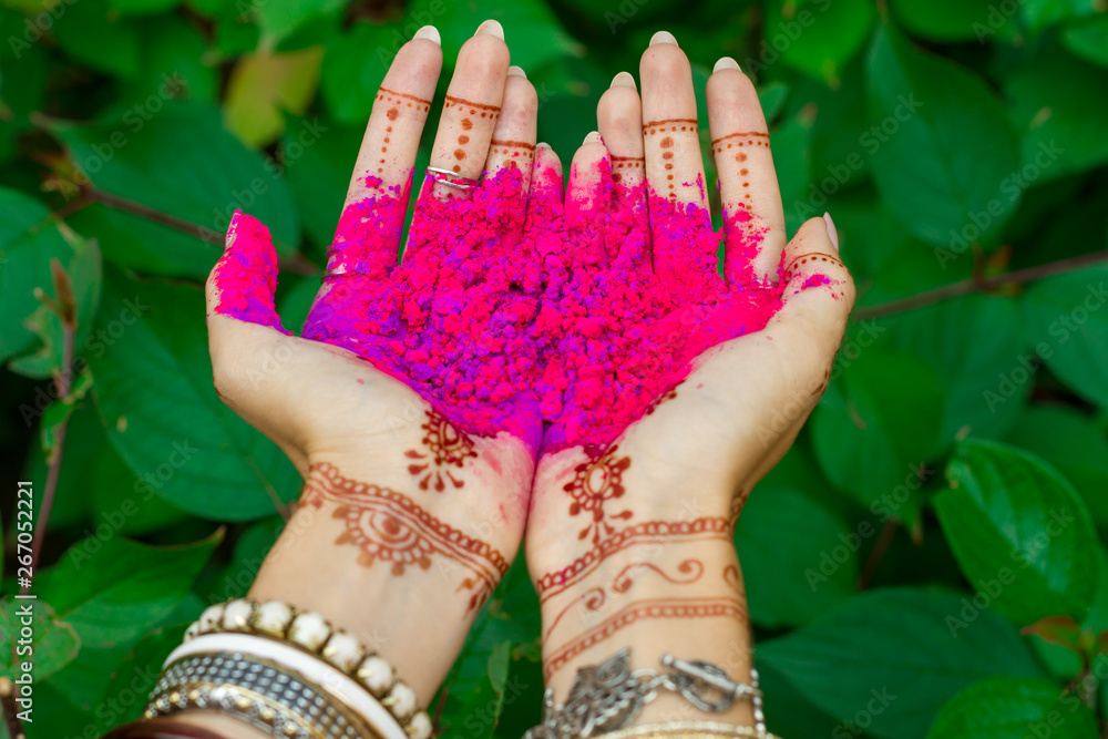 Beautiful woman hold in hands with henna tattoo and bracelets jewelry  colorful pink violet Holi dust powder paint Happy traditional Indian  wedding, holiday summer culture festival concept Green leaves Stock-Foto |  Adobe