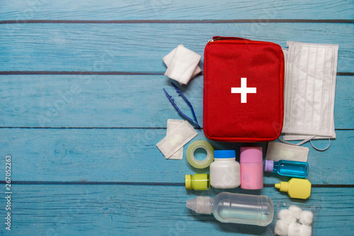 Top view first aid bag kid with medical supplies  on wood background.