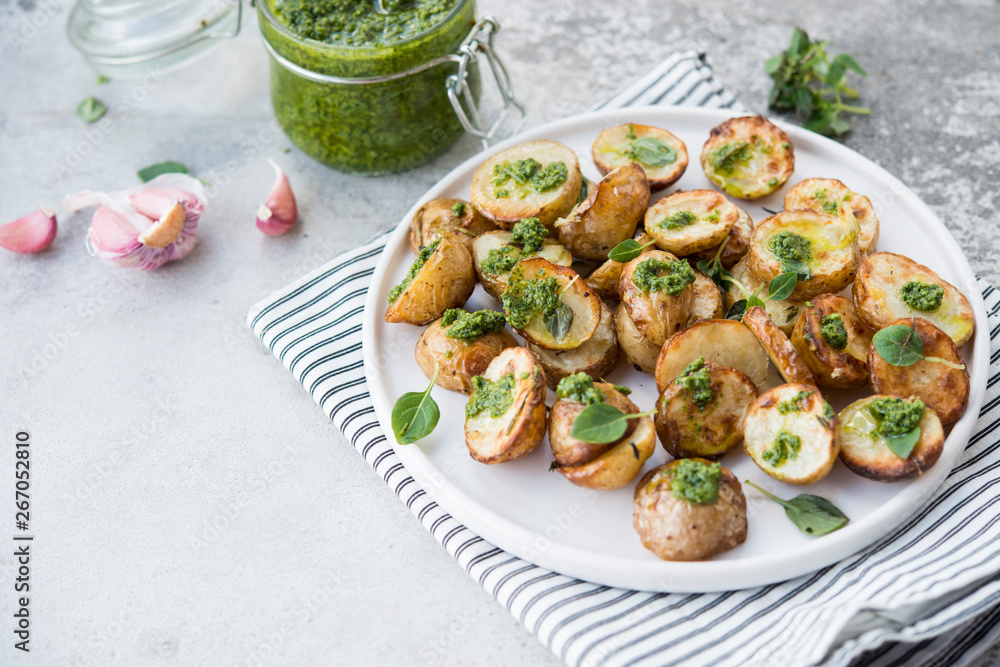 Baked potatoes in rustic style with green pesto sauce Baked potatoes in rustic style with green pesto sauce