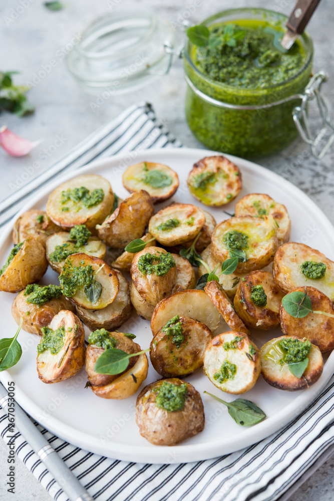 Baked potatoes in rustic style with green pesto sauce