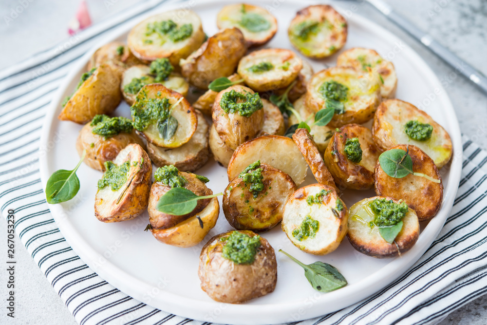 Baked potatoes in rustic style with green pesto sauce