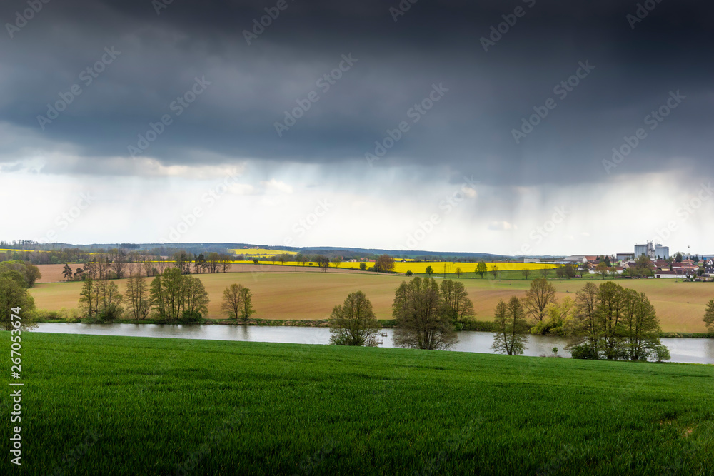 Springtime countryside with green pasture and sky with clouds