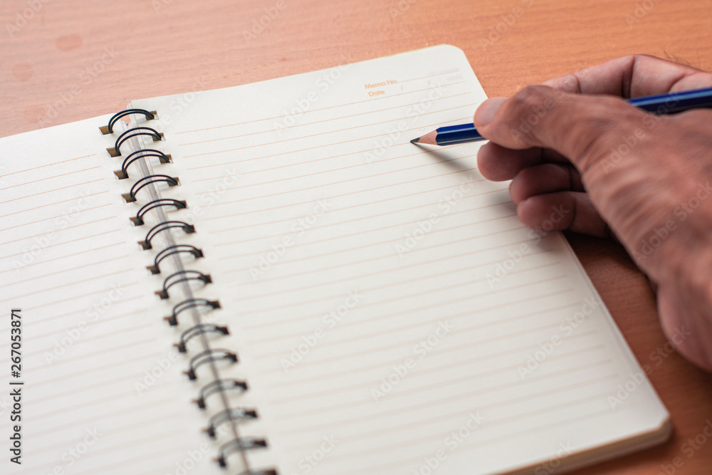 Notepad with pencil on wood board background.using wallpaper for Notepad with pencil on wood board background.using wallpaper for