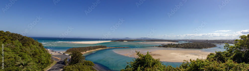panorama of flat sand dunes at delta of Nambucca river entering Pacific ocean through wide sandy beach of Australian coast around Nambucca heads town - aerial view