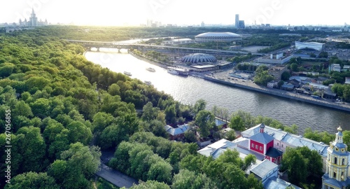 Wide angle vibrant view of sunny Sparrow Hill area in Moscow with boats, stadium, river, bridge and light leaks