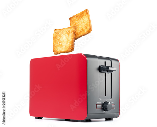 Roasted toast bread popping up of red toaster, isolated on white background. File contains a path to isolation. 