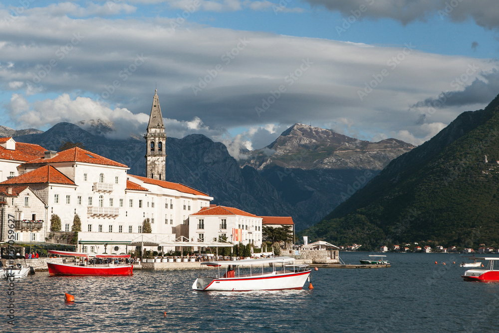Beautiful view of the old coastal town of Perast in Montenegro with beautiful architecture, the sea and boats on the background of the mountains.