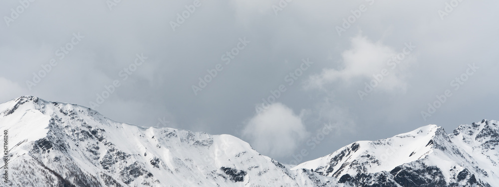 panorama mountain landscape with snowcapped peaks and expressive cloudscape
