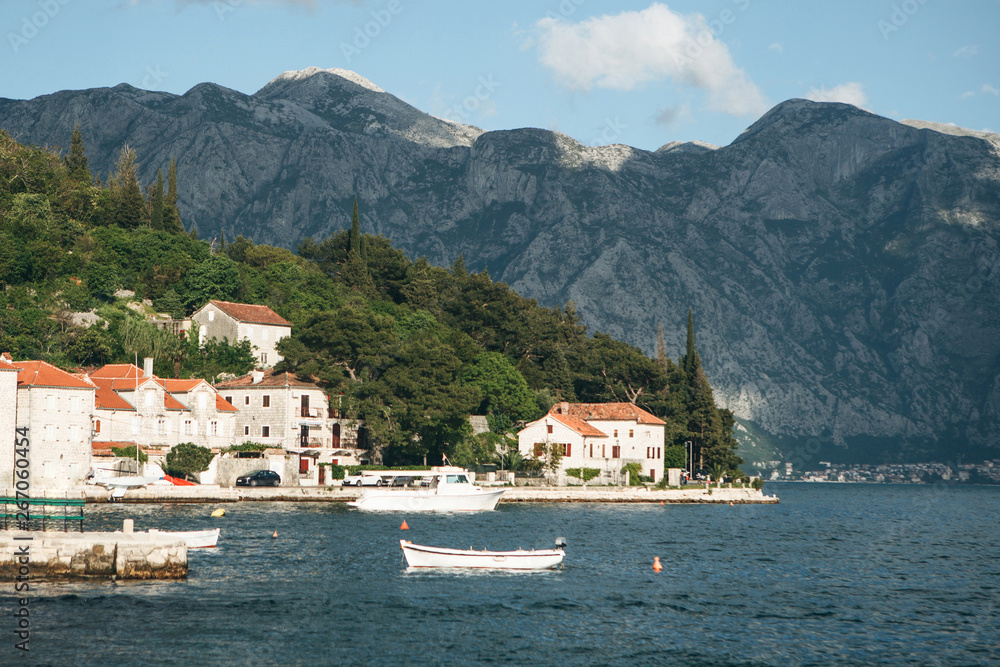 Beautiful view of the old coastal town of Perast in Montenegro with beautiful architecture, the sea and boats on the background of the mountains.