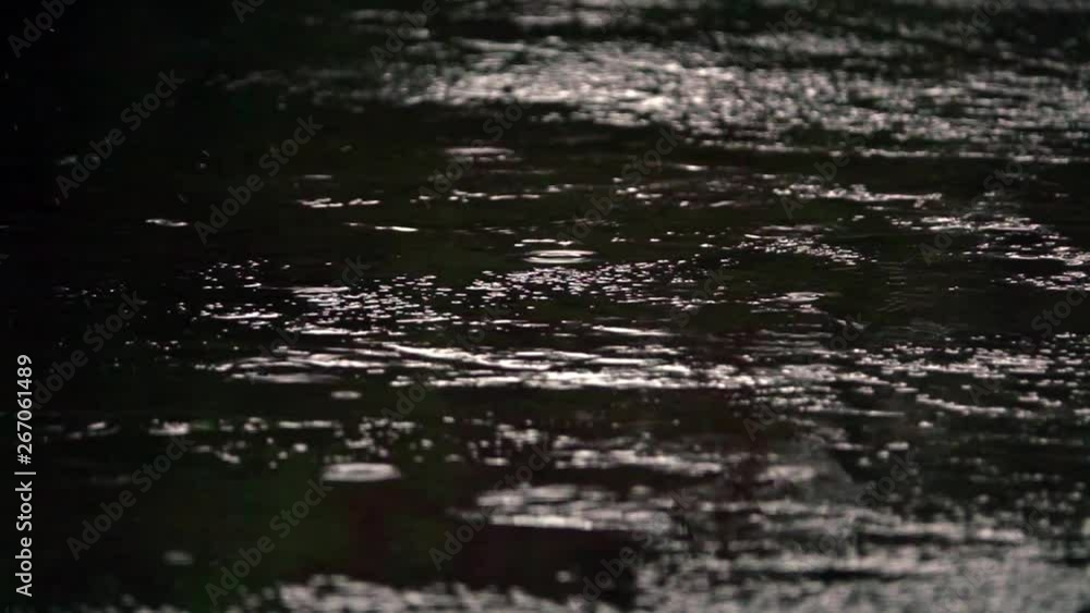 rain puddles on a pavement in the city, with black sky reflexion. Slow motion rain puddles on a pavement in the city, with black sky reflexion. Slow motion