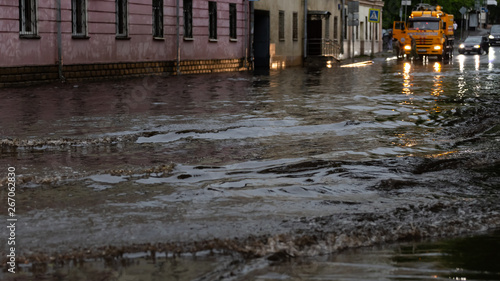 Cars drive through the flooded city