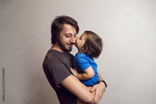 father in the gray shirt holding a son in a blue t-shirt in the hands