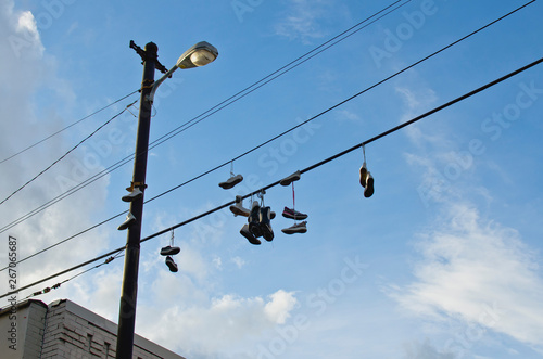 A lot of shoes hanging from the power lines in the back city streets. 
