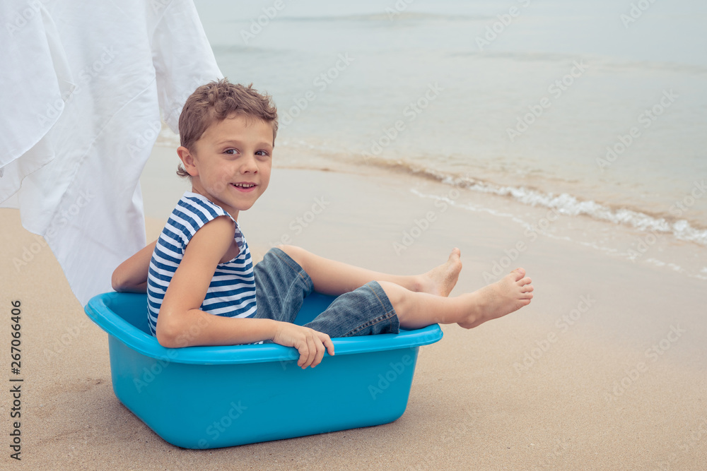 One happy little boy playing on the beach at the day time. One happy little boy playing on the beach at the day time.