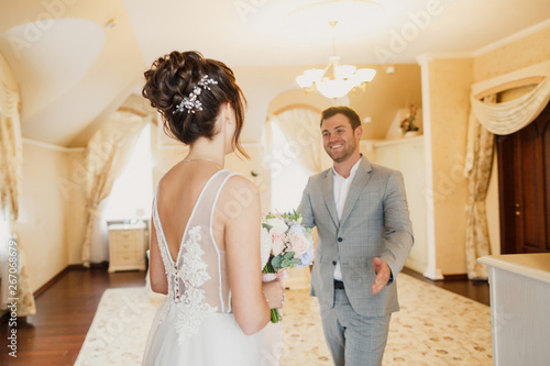 Photography young beautiful wedding couple are standing in a bright room in the apartment