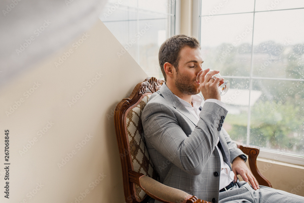 Portrait of a young male businessman in stylish clothes drink whiskey Portrait of a young male businessman in stylish clothes drink whiskey