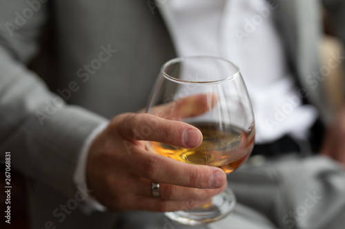 a glass of whiskey in the hands of a man