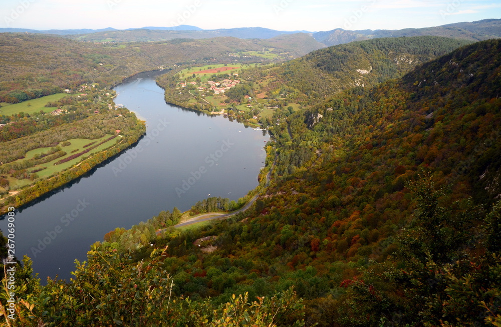 Aerial panoramic view on Ain River in France surrounded by autumn forest.