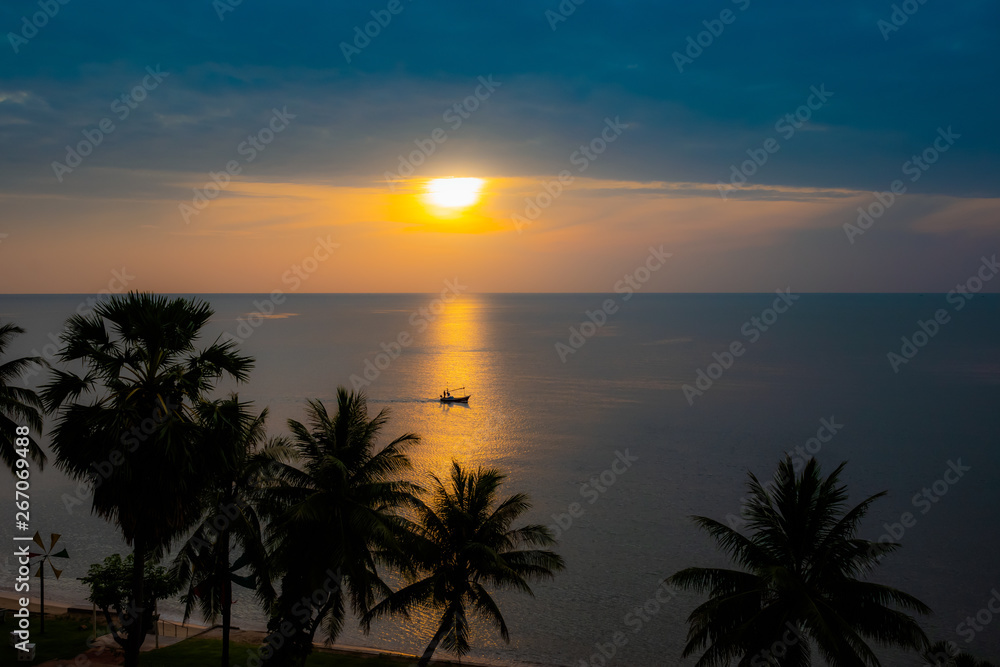 Silhouette fishing boat on skin sea water  color gold at sunrise time.