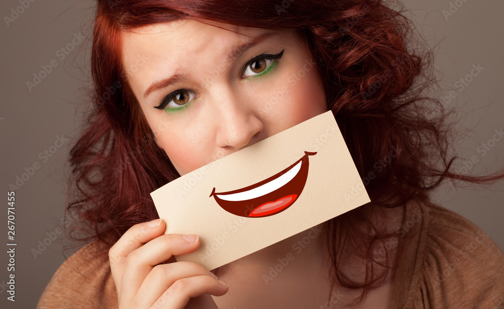 Person holding card in front of his mouth with ironic smile
Person holding card in front of his mouth with ironic smile