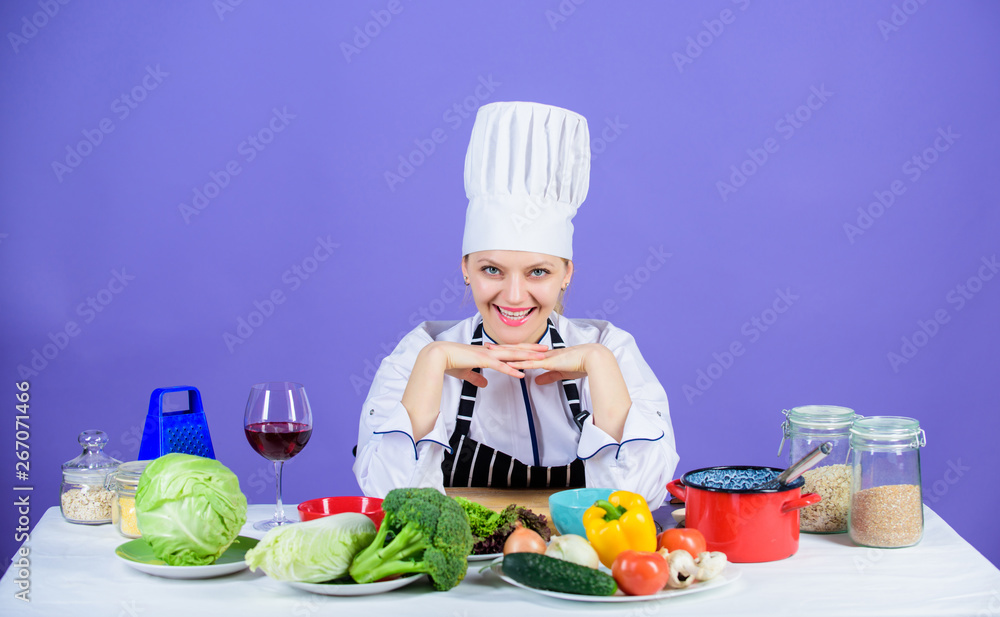 Fresh food every day. Happy cook preparing vegetarian food. Pretty chef smiling with organic natural food on kitchen table. Food containing almost zero calories Fresh food every day. Happy cook preparing vegetarian food. Pretty chef smiling with organic natural food on kitchen table. Food containing almost zero calories