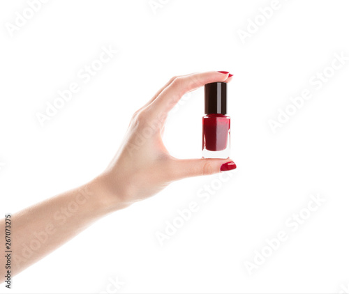 Very beautiful red nails close up. Female hand with long nails and bottle with bordo nail varnish.