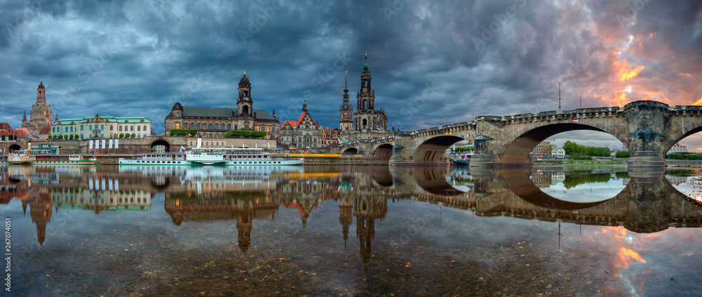 Dresden, Germany. Panoramic cityscape image of Dresden, Germany with reflection of the city in the Elbe river, during dramatic sunset.