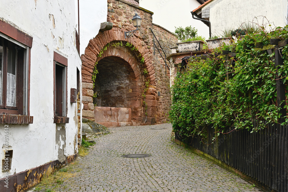 Old street in a medieval German town with the ruins of a fortress