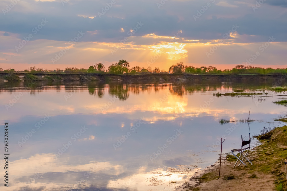 Sunset in the lake. beautiful sunset behind the clouds above the over lake landscape background. Summer Sunset in the lake. beautiful sunset behind the clouds above the over lake landscape background. Summer
