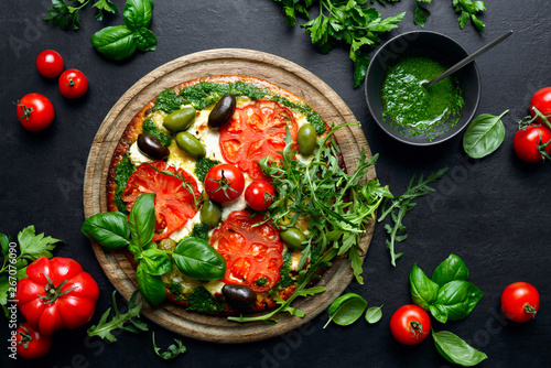 Pizza with green pesto and fresh tomatoes
