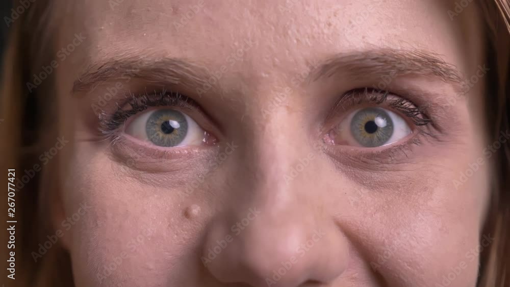 Close-up portrait of cute blonde model protruding her eyes in positive amusement on black background. Close-up portrait of cute blonde model protruding her eyes in positive amusement on black background.