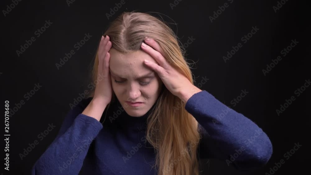 Portrait of depressed young blonde model with fuzz hair suffering from terrible headache on black background. Portrait of depressed young blonde model with fuzz hair suffering from terrible headache on black background.