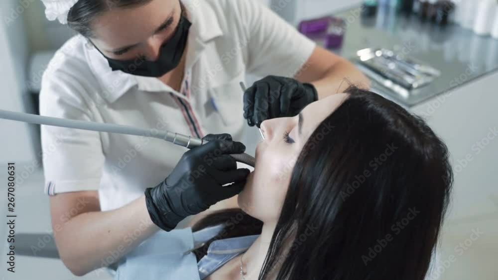 Dentist drills tooth to young woman, slow motion. Concept of dental treatment Dentist drills tooth to young woman, slow motion. Concept of dental treatment