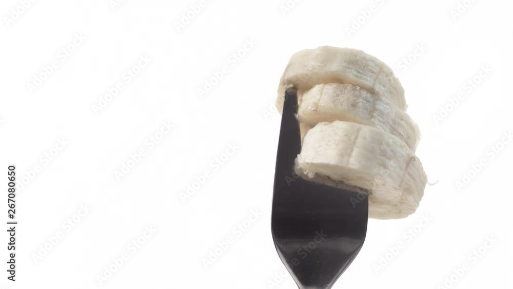 Sliced banana fruit on fork, white background. Healthy food organic nutrition Sliced banana fruit on fork, white background. Healthy food organic nutrition