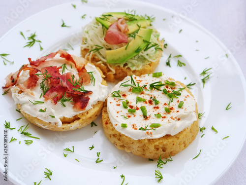 Keto canapes with cream cheese, bacon, avocado spread over almond mug bread slices