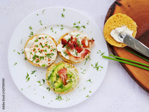 Foto Keto canapes with cream cheese, bacon, avocado spread over almond mug bread slic